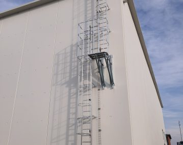 Scala con gabbia di protezione dotata di ballatoio intermedio di riposo e linea vita verticale anticaduta.